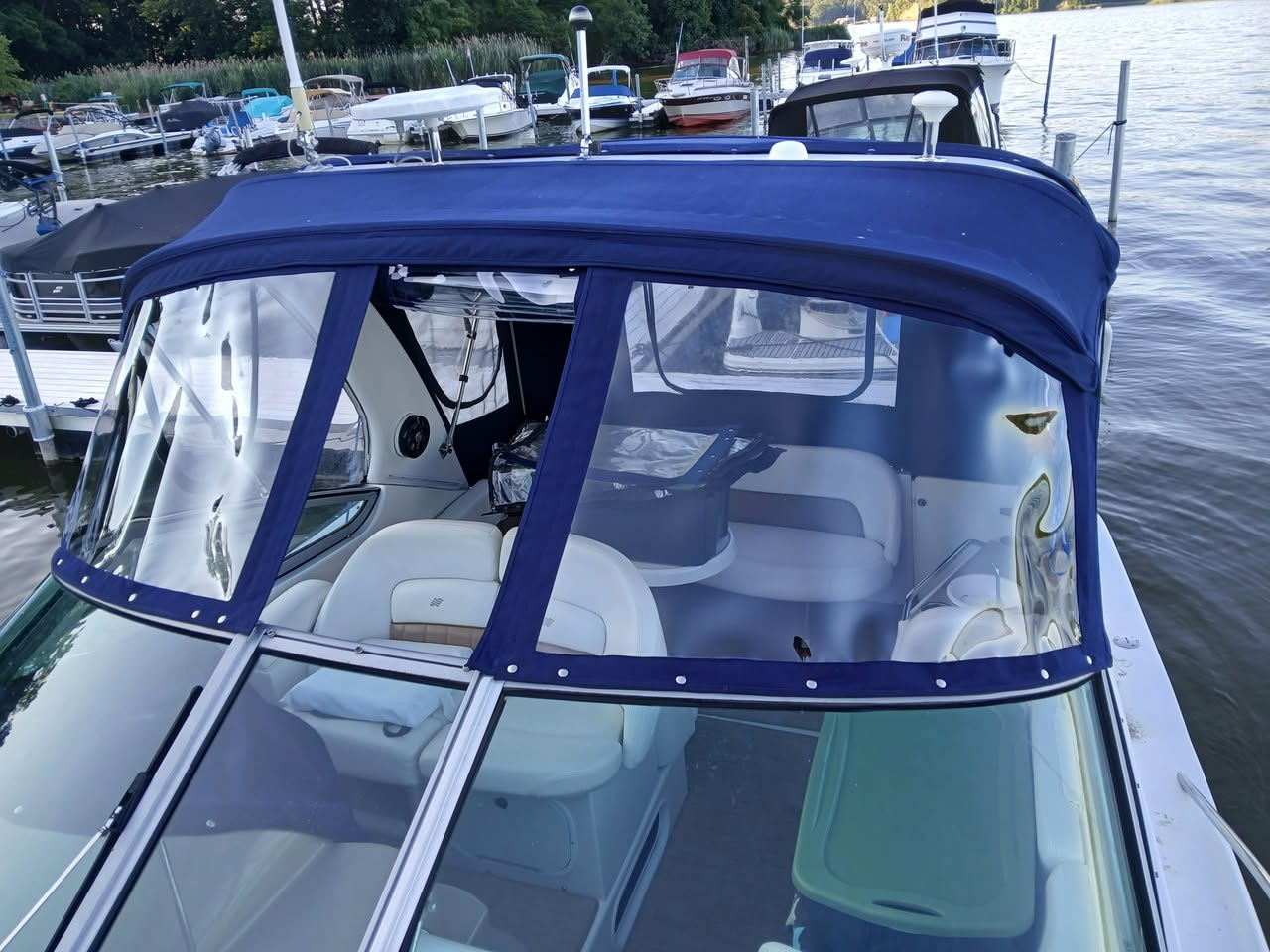 Blue custom enclosure with clear panels on a cruiser at the marina