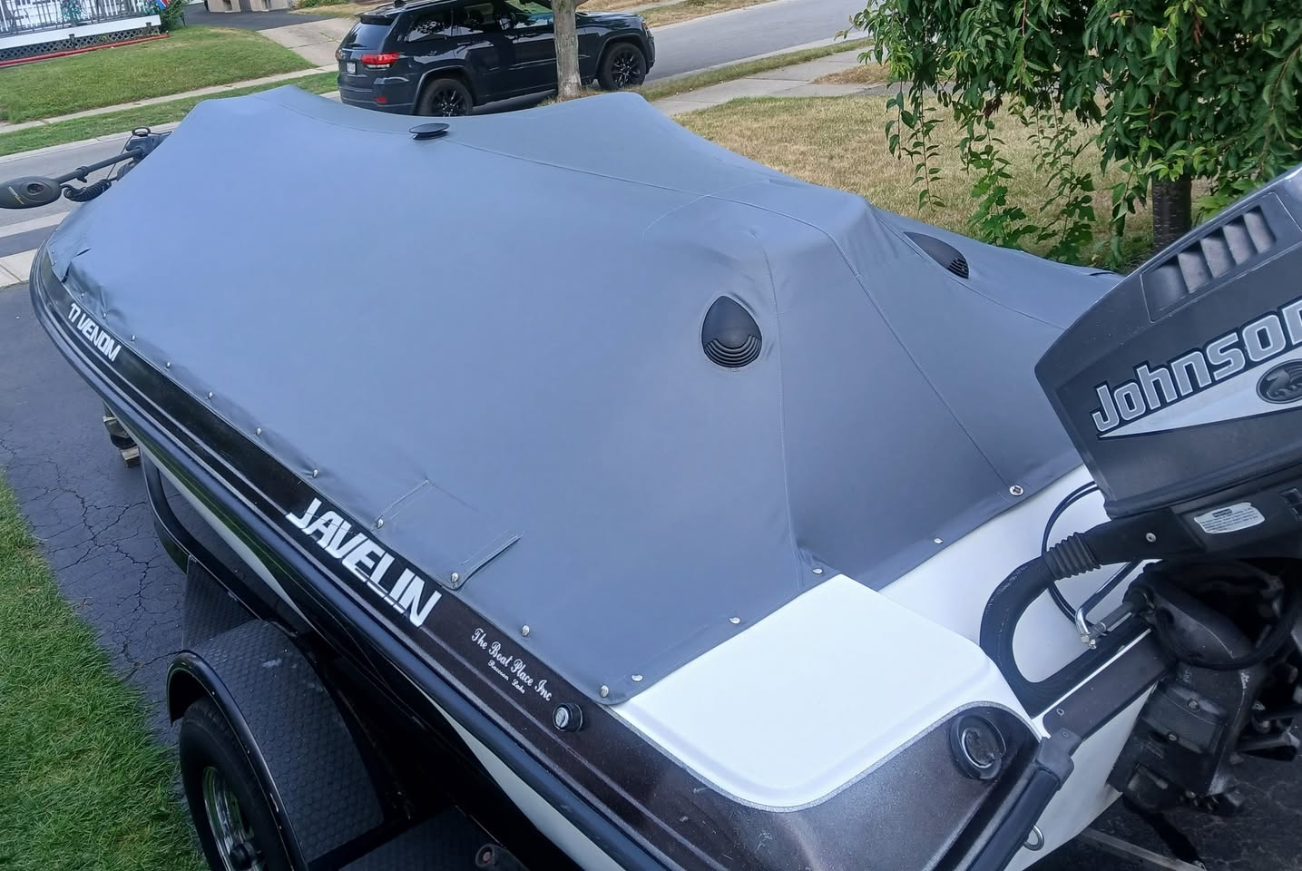 Gray custom travel cover fitted over a Javelin boat