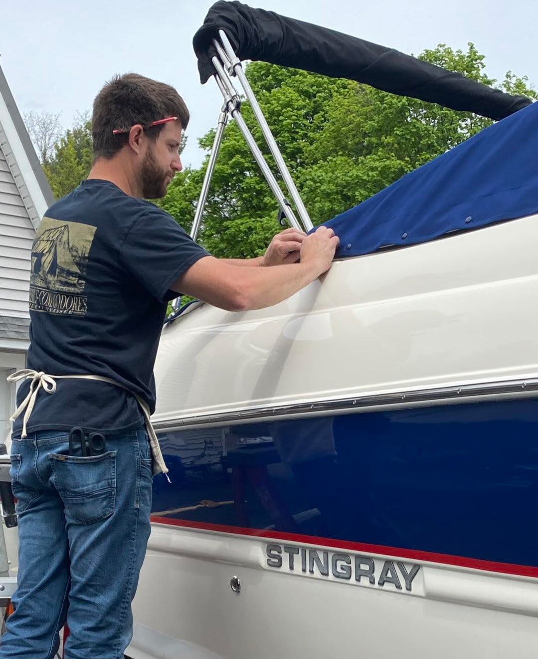 Tim McGee, owner of Rough Seas Canvas Company, fitting custom canvas on a Stingray boat